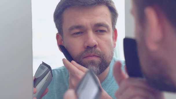 7 reglas para la barba que todos los hombres deberían seguir 3 Persona cepillándose la barba