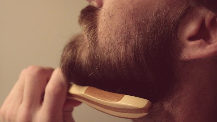 c&oacute;mo suavizar la barba, persona cepill&aacute;ndose.